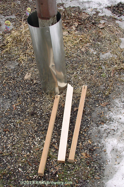 Tube shown at bottom of pole with 3 pieces of wood used to attach it to pole.